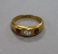 An 18ct gold and three stone gypsy set ruby and diamond ring, size K.