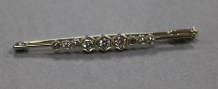 An 18ct white gold and graduated diamond set bar brooch, 51mm.