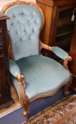 A Victorian walnut armchair, circa 1860, the carved spoon back, arms and serpentine seat covered