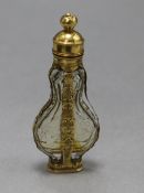 A late 18th century French yellow metal mounted glass scent bottle, with pierced removable finial,