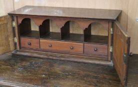 An oak two door cabinet, containing pigeon holes W.63cm