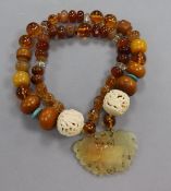 A string of assorted mixed beads with pierced jade wu fu pendant and dual pierced carved ivory
