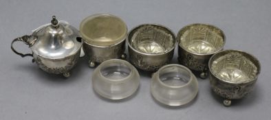 A late Victorian five piece condiment set with associated glass liners and tow other liners.