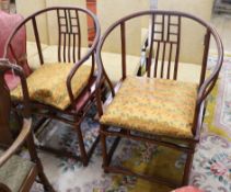 A pair of Chinese hardwood elbow chairs, with arched backs, simulating bamboo, solid seats, on