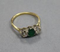 An 18ct gold, three stone emerald and diamond ring, size Q.