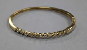 A 9ct gold and cubic zirconia? set hinged bangle, gross 11.8 grams.