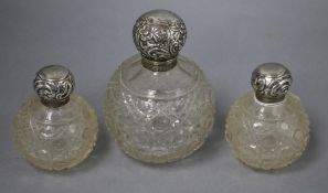 A pair of Edwardian silver mounted cut glass scent bottles and a larger late Victorian scent bottle,