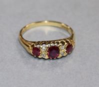 An early 20th century 18ct gold, ruby and diamond half hoop ring, size Q.