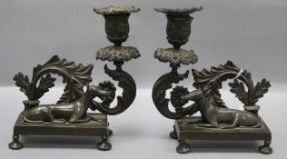 A pair of Regency cast bronze candlesticks, the bases mounted with recumbent hounds height 18cm