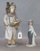 A Lladro hurdy gurdy player and a milestone figure tallest 34cm