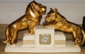 A Rozay ceramic Art Deco clock mounted with lion cubs length 58cm
