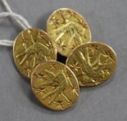 A pair of yellow metal cufflinks engraved with aesthetic birds.