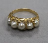 A yellow metal and graduated five stone split pearl half hoop ring, size J.