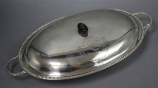 A George III silver oval two handled entree dish and cover, with beaded border and engraved crest