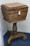 A Victorian mahogany teapoy, circa 1840, on baluster-turned column and scrolled tripartite