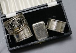 Three serviette rings including two silver and a silver vesta case.