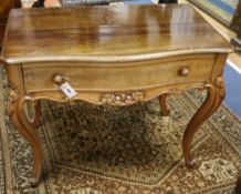 A carved walnut side table, circa 1860, of serpentine form, fitted frieze drawers, on moulded