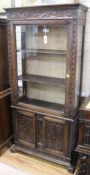 A Spanish carved walnut display cabinet,19th century, having glazed door and shelved interior over a