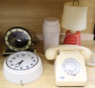 A cream bakelite telephone, a bakelite lamp, a thermos flask and two clocks