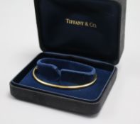 A Tiffany & Co 9ct gold bangle, with Tiffany & Co boxes.