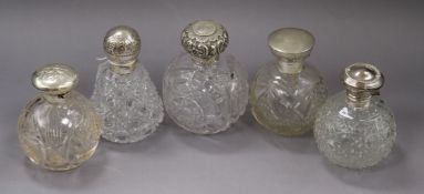 Five assorted Late Victorian and later silver topped cut glass scent bottles only one with stopper),