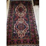 A Caucasian dark red ground rug 205 x 115cm