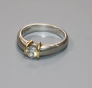 A modern platinum and solitaire diamond ring, in a yellow gold setting, the stone weighing