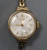 A lady's 9ct gold Longines manual wind wrist watch, on a 9ct gold bracelet (af).