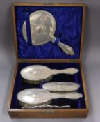 A cased George V repousse silver five piece dressing table set, Chester, 1912.