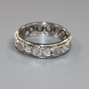 A carved white metal and diamond set eternity ring, size