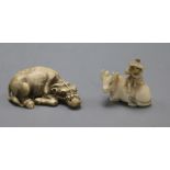 Two early 20th century Japanese ivory netsuke of an ox, one surmounted by a man