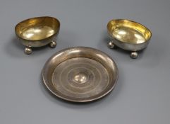 A pair of silver oval salts and a small silver dish.