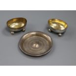 A pair of silver oval salts and a small silver dish.