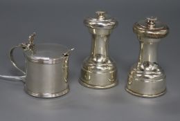 A pair of George V silver pepper grinders by Hukin & Heath and a silver mustard pot.