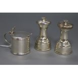 A pair of George V silver pepper grinders by Hukin & Heath and a silver mustard pot.
