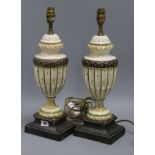 A pair of cream and green urn shaped table lamps