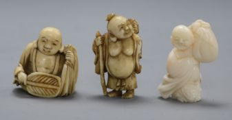 Three early 20th century Japanese netsuke of Hotei, two in ivory, one coral