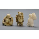 Three early 20th century Japanese netsuke of Hotei, two in ivory, one coral