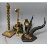 A pair of stoneware figures, mounted horns and two brass table lamps