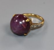 An 18ct gold and cabochon star ruby set ring, with diamond set shoulders, size K.
