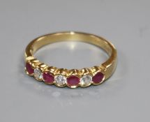 An 18ct yellow gold, ruby and diamond seven-stone ring, collet-set size P/Q.