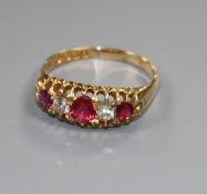 An Edwardian 18ct gold five stone ruby and diamond half hoop ring, size R.