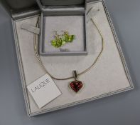 A Lalique 'Coeur' red stone locket on chain and a pair of Lalique 'Papillon' green crystal earrings,