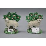 A pair of Staffordshire pottery models of sheep with bocage tallest 13cm