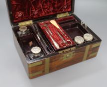 A Victorian brass mounted rosewood toilet box, containing four silver mounted bottles and four