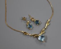 A heart-shaped aquamarine and diamond pendant on a yellow metal fine link chain and a pair of