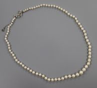 A 1920's/1930's single strand graduated cultured pearl necklace with white metal and diamond set bow