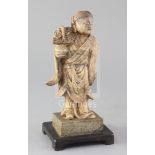 A Chinese creamy soapstone figure of He Xiangu, 19th century, holding a basket in her right hand,