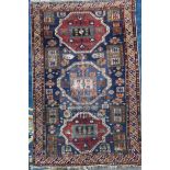 A Shirvan blue ground rug, with three central polygons in a field of geometric hooked motifs, with