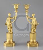 A pair of Regency gilt brass chinoiserie candlesticks, each modelled as a female figure holding a